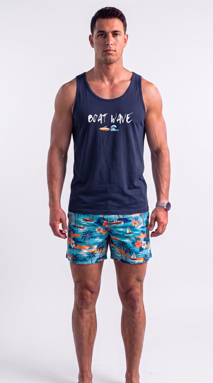 A man modeling a navy blue tank top with 'BOAT WAVE' printed on the chest and colorful tropical print swim trunks, shot against a plain light gray studio background.